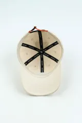 Gorra de béisbol color beige con logo bordado en el frente.