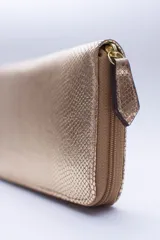 Billetera marrón con estampado de piel de serpiente, cierre perimetral, múltiples ranuras para tarjetas, documentos y billetes, y bolsillo interior con cierre para monedas.