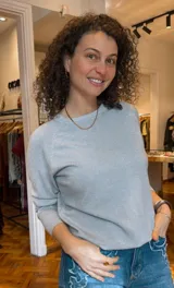 Buzo de lurex color celeste con cuello redondo y mangas largas.