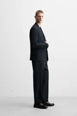 Pantalón de vestir azul marino, de corte recto, con pinzas frontales, bolsillos laterales y traseros con doble vivo y botón.