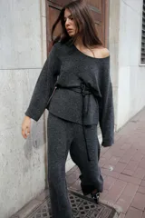 Top de punto color gris oscuro con escote redondo y mangas largas acampanadas.