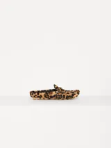 Mocasín de cuero vacuno con estampado animal print, detalle metálico en forma de corazón y suela de goma.