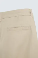 Pantalón chino color verde militar, de corte recto, con bolsillos laterales y traseros de vivo. Cierre frontal con cremallera y botón.