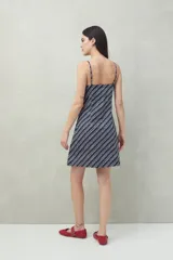 Vestido corto azul marino con estampado de lunares blancos y rayas diagonales blancas.