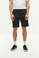 Short de felpa negro con textura, bolsillos laterales y trasero, cintura regulable y logo bordado.