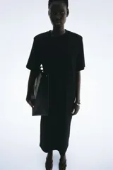 Vestido largo (tobillero) negro de corte recto y holgado, tipo remerón, con cuello redondo y mangas cortas.