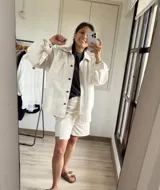 Sobrecamisa color crudo de gabardina, con cuello camisero, cierre frontal con botones a presión, manga larga con puños abotonados, bolsillos de parche en el pecho y corte holgado.