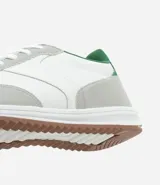 Championes deportivos de cuero color blanco con detalles en gris y verde.