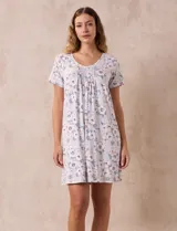 Camisón corto negro con lunares blancos, de tejido suave y escote redondo con detalle plisado y moño blanco.