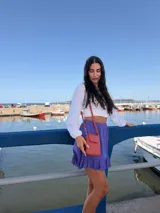 Bandolera pequeña y compacta color amarillo mostaza, realizada en símil cuero. Posee un bolsillo frontal con tapa y broche metálico, y un compartimento principal con cierre superior. Incluye correa ajustable del mismo material.