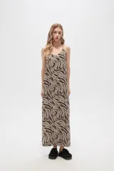 Vestido largo con estampado animal print en tonos beige y negro, breteles finos y corte holgado.