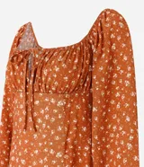 Vestido midi color ladrillo con estampado floral blanco, escote cuadrado con lazo ajustable, mangas largas abullonadas y abertura lateral en la falda.
