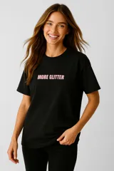 Remera negra de algodón con estampa frontal con la frase "More Glitter" en color rosa.