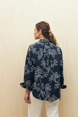 Camisa blanca de manga larga confeccionada en algodón liviano con calados florales. De corte clásico y botones frontales.