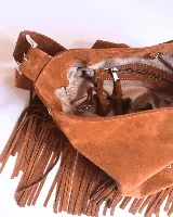 Bandolera de cuero color beige con flecos y tachas plateadas.