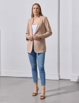 Blazer color beige, entallado, con cuello con solapa, abertura central con botón y bolsillos delanteros.