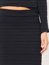 Pollera larga negra de punto fantasía con cintura elastizada y silueta fluida.