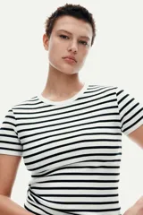 Remera de punto acanalado a rayas horizontales blancas y negras, de corte ajustado, cuello redondo y mangas cortas.