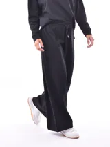 Pantalón negro de corte ancho y tiro alto con cintura elástica ajustable mediante cordón.