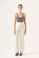 Pantalón palazzo negro de tiro alto, confeccionado en cupro y viscosa. Cuenta con bolsillos diagonales laterales, bolsillos ojal falsos en la espalda y cierre lateral invisible.