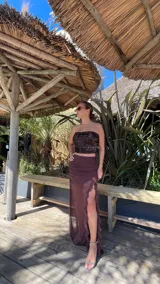 Pollera larga color marrón, con fruncido en la cintura, transparencias y volados verticales en la abertura lateral.