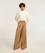 Pantalón pantalona de sastrería color beige, con trabillas en la cintura y pliegues delanteros.