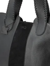 Cartera shopper negra de cuero graneado con panel central de gamuza. Tiene manijas con costuras en cuero y logo metálico de la marca.