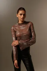 Blusa marrón con brillos plateados, cuello alto y mangas largas acampanadas.