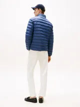 Campera acolchada Tommy Hilfiger de nailon color azul, con diseño plegable y acabado repelente al agua. Posee cuello alto, cierre frontal de cremallera, bolsillos laterales con cierre y logo de la marca bordado en el pecho.