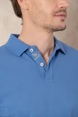 Remera tipo polo color beige, de manga corta y corte clásico. Tiene cuello con botones y está confeccionada en algodón.