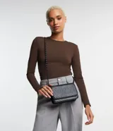 Cartera pequeña negra con textura animal print, correa de cadena y cierre con botón a presión.