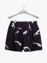 Shorts negros con estampado de figuras humanas en color blanco.