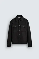 Sobrecamisa negra de corte regular fit confeccionada en tejido efecto ante. Cuenta con cuello solapa, manga larga con puños abotonados, bolsillos de plastrón con solapa en el pecho y bolsillos de vivo en la cadera. Cierre frontal con botonadura.