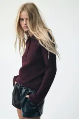 Sweater de punto texturizado color borgoña, de manga larga, con cuello polo y tapeta de cinco botones.