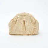 Bolso bandolera color beige, tejido en rafia con patrón de espiga. Tiene forma rectangular con cierre superior fruncido y cadena dorada para colgar al hombro.