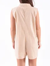 Mono corto color beige, con cuello camisero, sin mangas y cierre frontal con botones.