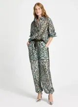 Pantalón de tiro alto confeccionado en tejido similar al lino con estampado animal, cintura elástica con cordón, cuatro bolsillos, banda lateral, bajos ajustables y acabado pespunteado.