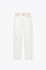 Pantalón de jean color crudo, corte mom fit, tiro alto y cintura combinada en color beige.