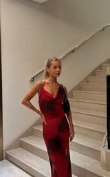 Vestido largo de microtul rojo con estampado abstracto negro, escote drapeado y breteles finos.