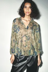 Camisa de manga larga con cuello solapa y estampado abstracto en tonos verde, marrón y azul.