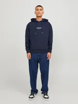 Canguro azul marino de manga larga con capucha, corte relajado y bolsillo tipo canguro. Estampado en el pecho con la leyenda "Originals Studio BROUGHT TO YOU BY JACK&JONES DESIGNED IN COPENHAGEN" en letras blancas.