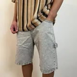 Bermuda de jean de corte holgado estilo mom/carpintero, con lavado ácido gris claro y dobladillo deshilachado.