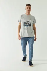 Remera gris de manga corta con estampa fotográfica de un edificio enmarcada en un cuadrado negro.