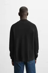 Cárdigan negro de punto con cuello solapa, manga larga y cierre frontal con botones. Tejido con hilatura de viscosa y acabado en rib.