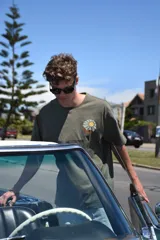 Remera verde militar de manga corta con cuello redondo y estampado de un sol sobre una montaña.