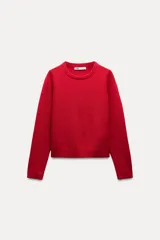 Jersey rojo de punto liso confeccionado en 100% lana. Tiene cuello redondo, manga larga y acabados en rib.