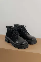 Borcegos negros de cuero charol, con punta cuadrada, cordones y suela track.