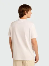 Remera de algodón color blanco roto con cuello redondo y un pequeño logo de estrella negra estampada en el pecho.