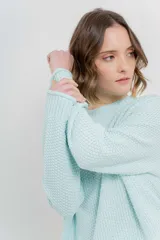 Sweater azul de punto medio, amplio, suave, con escote a la base y puños en mangas y en acabado inferior.