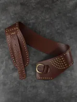 Cinturón ancho de cuero sintético color marrón con tachas doradas y hebilla metálica.
